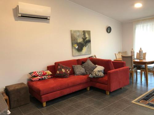 a red couch sitting in a living room at York - Mulyinjinin Valley Cottage in York