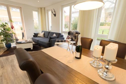 ein Wohnzimmer mit einem Tisch und einer Flasche Wein in der Unterkunft Harz Cottage in Bad Lauterberg