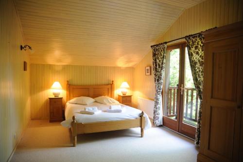 a bedroom with a bed with two lamps and a window at Résidence Souillac Golf & Country Club in Lachapelle-Auzac