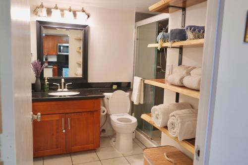 a bathroom with a toilet and a sink and a mirror at Ilikai Hotel Condo with Kitchen and Ocean View in Honolulu