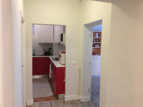 a kitchen with red cabinets and a white appliances at Le Camere di Casa Cassandra in Perugia
