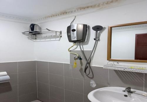 a bathroom with a sink and a mirror at Hotel Green Town Port Dickson in Port Dickson