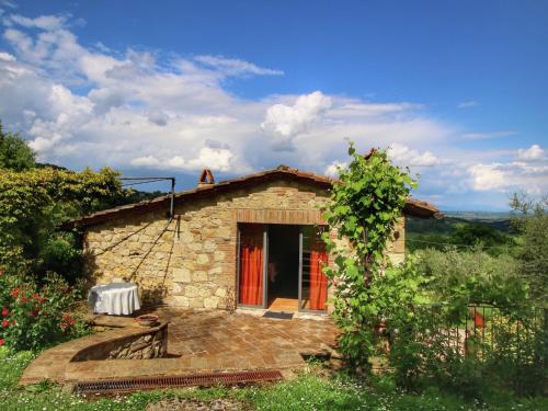 a small stone house with a red door at Belvilla by OYO Villa Valardegna in Montepulciano