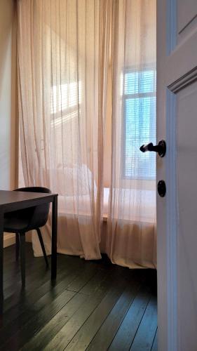una stanza con una finestra con una scrivania e un tavolo di OYO rooms a Courtrai