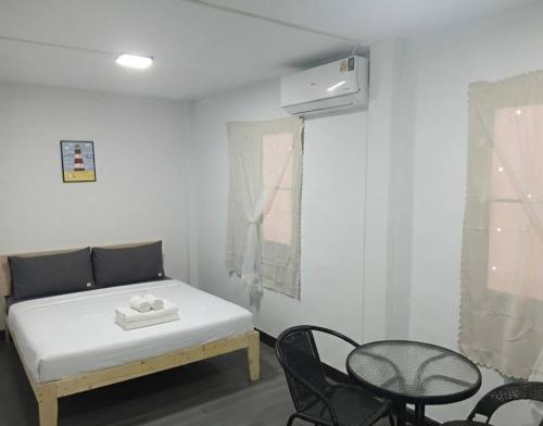 a bedroom with a bed and a table and chairs at Middle Road Hostel in Nathon Bay