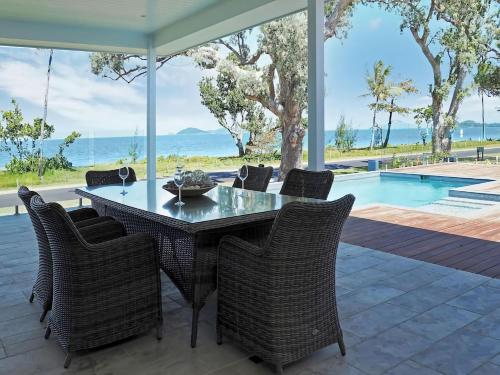 a dining room with a table and chairs and a pool at Solace in South Mission Beach