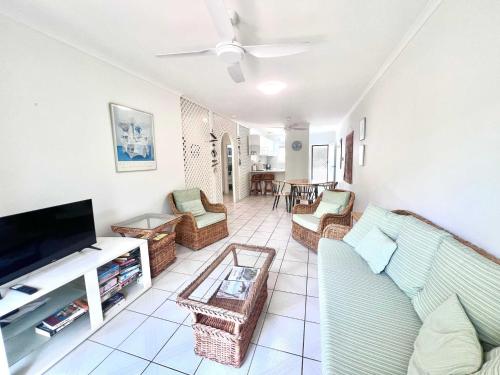 a living room with a couch and a flat screen tv at Kirrama 4 Family Beachside Escape in Mission Beach
