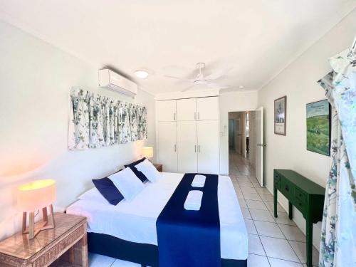 a bedroom with a bed with a blue and white comforter at Kirrama 4 Family Beachside Escape in Mission Beach