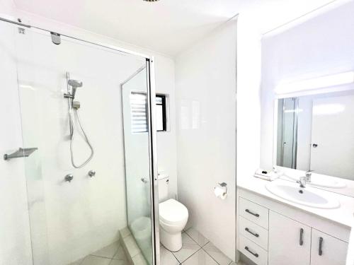 a bathroom with a shower and a toilet and a sink at Kirrama 4 Family Beachside Escape in Mission Beach