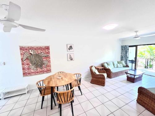 a living room with a table and a couch at Kirrama 4 Family Beachside Escape in Mission Beach