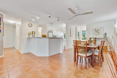 a kitchen and dining room with a table and chairs at Ulysses 10 Ocean Dunk Island Views in Mission Beach