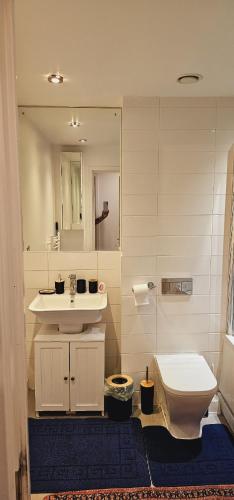a bathroom with a sink and a toilet and a mirror at Excellent 2 bedroom Apartment- great Connectivity to central london in Barking