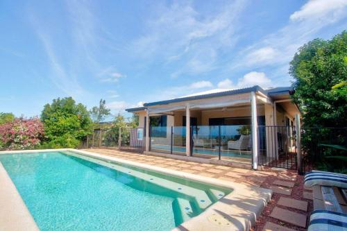 a swimming pool in front of a house at Le Reve Wake up to sunrises and tropical breezes in Mission Beach