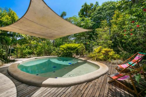 a swimming pool on a wooden deck with a umbrella at Secret Mission Pet friendly in South Mission Beach