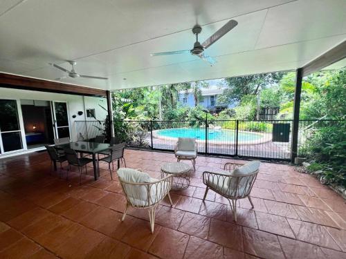 a patio with chairs and a table and a pool at Secret Mission Pet friendly in South Mission Beach
