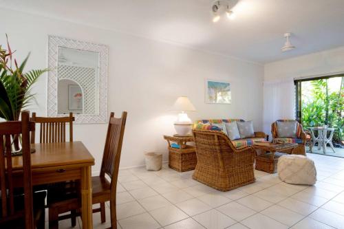 a living room with a table and chairs at Kirrama 2 Pool across road to beach in Mission Beach