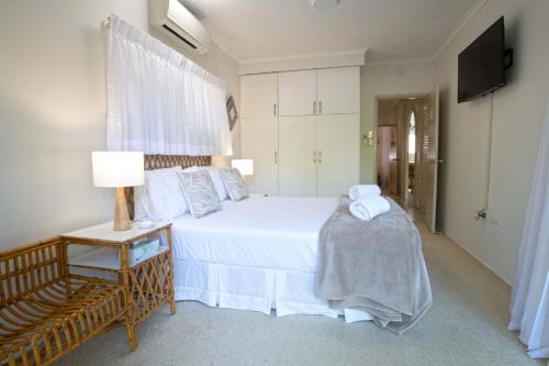 a bedroom with a large white bed and a chair at Kirrama 2 Pool across road to beach in Mission Beach