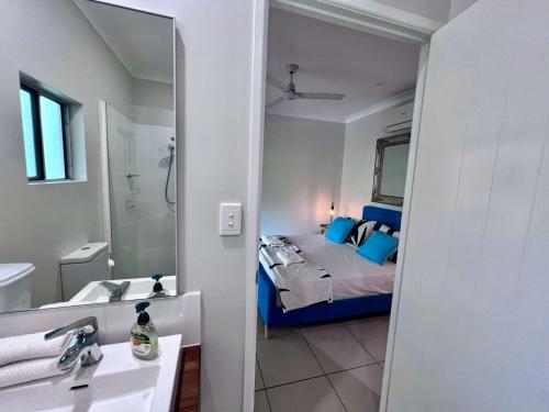 a bathroom with a bed and a sink and a mirror at Secret Mission Pet friendly in South Mission Beach