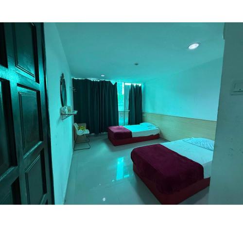 a bedroom with two beds and a door and a window at OYO 91288 Hotel PARADISE BATU CAVES in Batu Caves