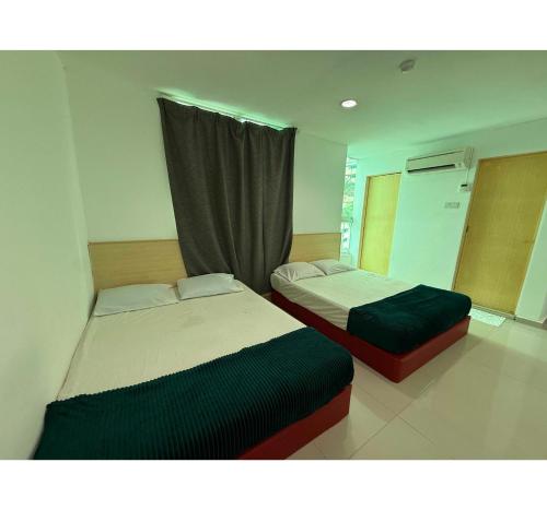 two beds in a room with a window at OYO 91288 Hotel PARADISE BATU CAVES in Batu Caves