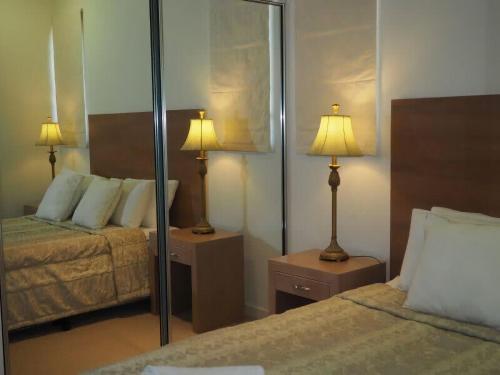 a hotel room with two beds and a mirror at BHA 1 Beachfront Haven fullhouse in Mission Beach