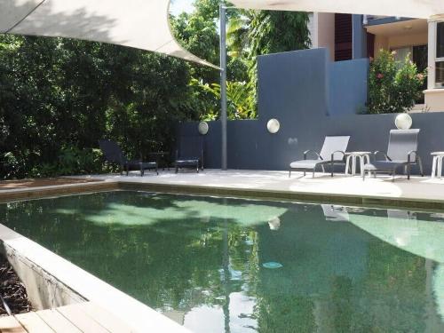 a swimming pool with some chairs and some water at BHA 1 Beachfront Haven Fullhouse in Mission Beach