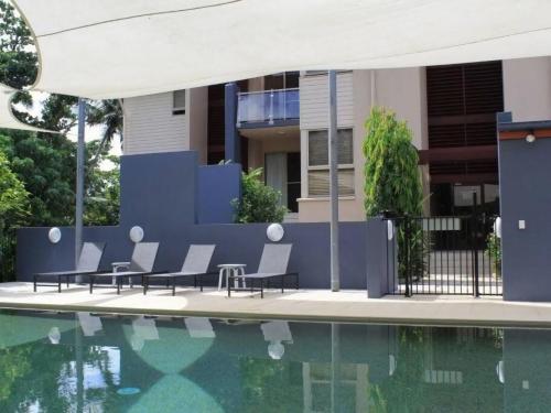 a swimming pool with chairs next to a house at BHA 4 Beachfront Bliss 2 bed in Mission Beach