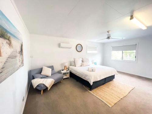 a bedroom with a king sized bed and a couch at Bella Luna Beach Front Full house in South Mission Beach