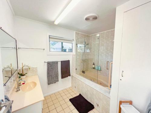 a white bathroom with a sink and a shower at Bella Luna Beach Front Full house in South Mission Beach