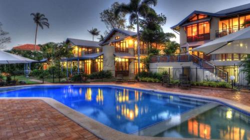 a house with a swimming pool in front of a house at Wongalinga Absolute Beachfront Unit 9 2 Bedroom in Mission Beach