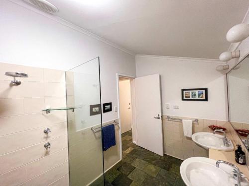 a bathroom with two sinks and a shower at Wongalinga Absolute Beachfront Unit 9 2 Bedroom in Mission Beach