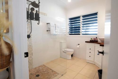 a white bathroom with a toilet and a shower at Tide Pool Ocean Front Full house in South Mission Beach