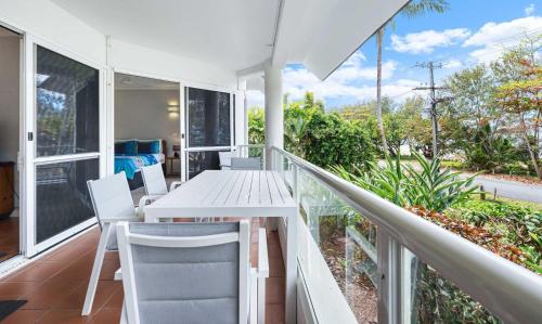 a porch with a white table and chairs on a balcony at Ulysses One Beachfront Escape 1 Bedroom in Mission Beach