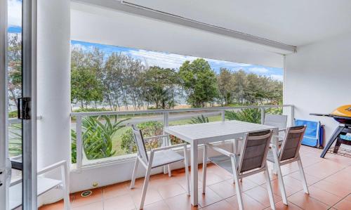 a dining room with a table and chairs and a balcony at Ulysses One Beachfront Escape 2 Bedroom Spacious in Mission Beach
