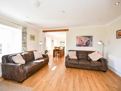 a living room with two brown leather couches at Heron View in Kirkcudbright