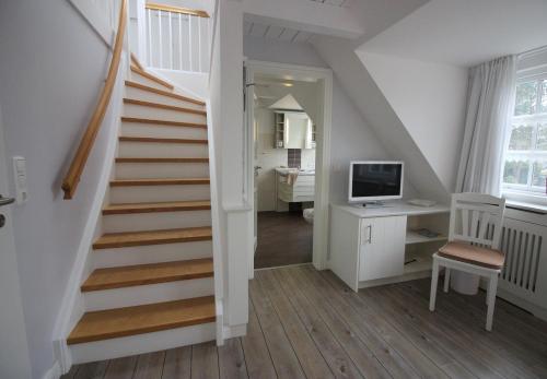 a staircase with a desk and a computer in a room at Ual Öömrang Wiartshüs in Norddorf