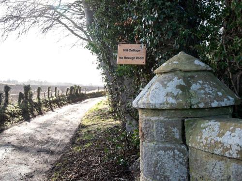 a sign on a wall next to a dirt road at Mill Cottage-Uk7348 in Dyke