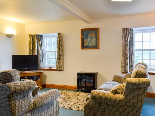 a living room with two chairs and a fire place at The Stable - 31240 in Kilmartin