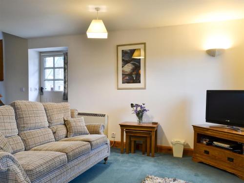 a living room with a couch and a tv at The Stable - 31240 in Kilmartin