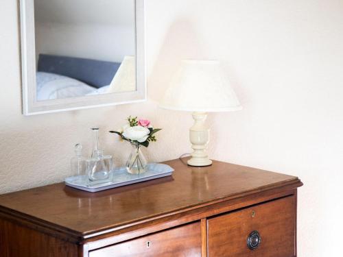 a table with a lamp and a vase of flowers on it at Mill Cottage-Uk7348 in Dyke
