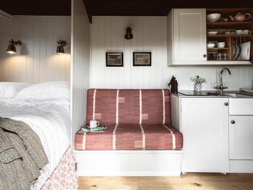 a bedroom with a bed and a sink and a bench at Lapwing Shepherds Hut - Uk7631 in Pitlochry