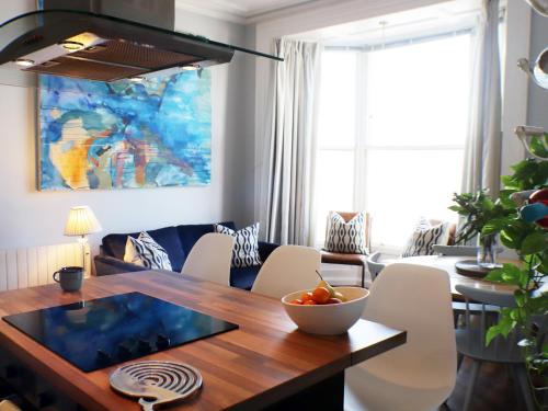 a dining room table with a bowl of fruit on it at Seaside Apartment-Uk2801 in Aberystwyth