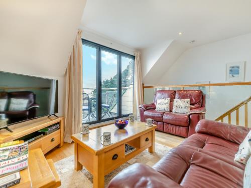 a living room with a couch and a tv at 23 Mount Brioni in Downderry