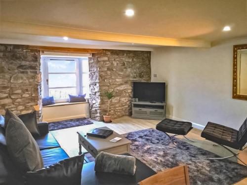 a living room with a couch and a tv at Imperial Apartment in Oban