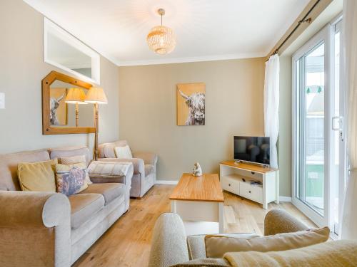 a living room with a couch and a tv at Anchors Away - 29566 in Blue Anchor