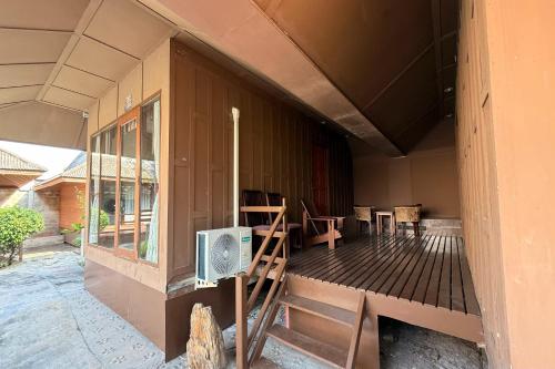 a porch of a house with chairs and a fan at The Grand Imperial in Ban Song Hong