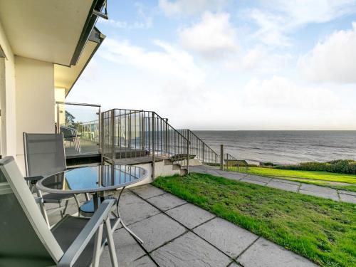 a balcony with a table and chairs and the ocean at 21 Mount Brioni in Downderry