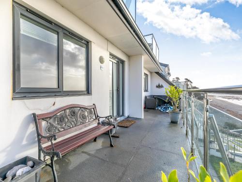 a bench sitting on the side of a building with a window at 18 Mount Brioni in Downderry
