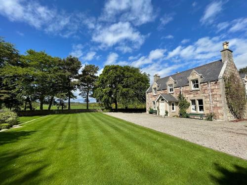 an old stone house with a large green lawn at Balloan House-Uk7383 in Dornoch