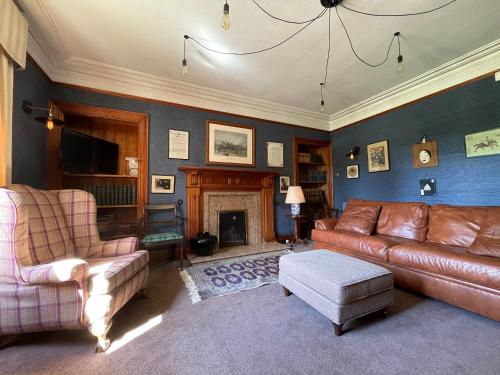 a living room with a couch and a fireplace at Balloan House-Uk7383 in Dornoch